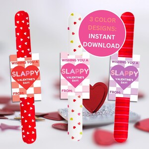May include: Valentine's Day gift tags with a playful design. Each tag features a 'slappy' heart graphic and the text 'Wishing You a Slappy Valentine's Day!' with space to write 'From:'. The tags come in three color designs and are attached to a red paddle.