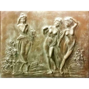 May include: A bronze-colored relief sculpture depicting three figures in classical attire. One figure holds flowers, while the others are draped in fabric. The artwork features detailed textures and a classical theme, with floral elements.