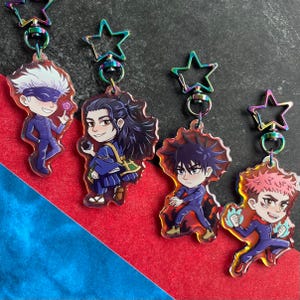 May include: Four anime-style character keychains. Each keychain features a colorful, detailed illustration of a character with a star-shaped clasp. The characters are dressed in various outfits and poses, with vibrant colors and dynamic expressions.