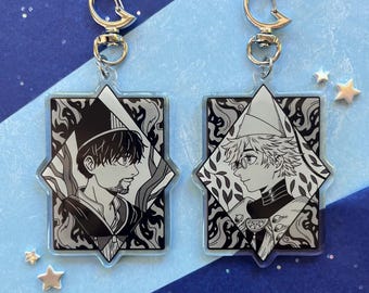 May include: Two clear acrylic keychains featuring black and white anime-style character illustrations. Each rectangular charm has a pointed top and bottom, a silver moon-shaped clasp, and depicts a profile view of a person in detailed attire.
