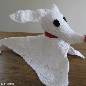 May include: White crocheted plush toy shaped like Zero from the Nightmare Before Christmas. The toy has black eyes, a red nose, and a red collar.