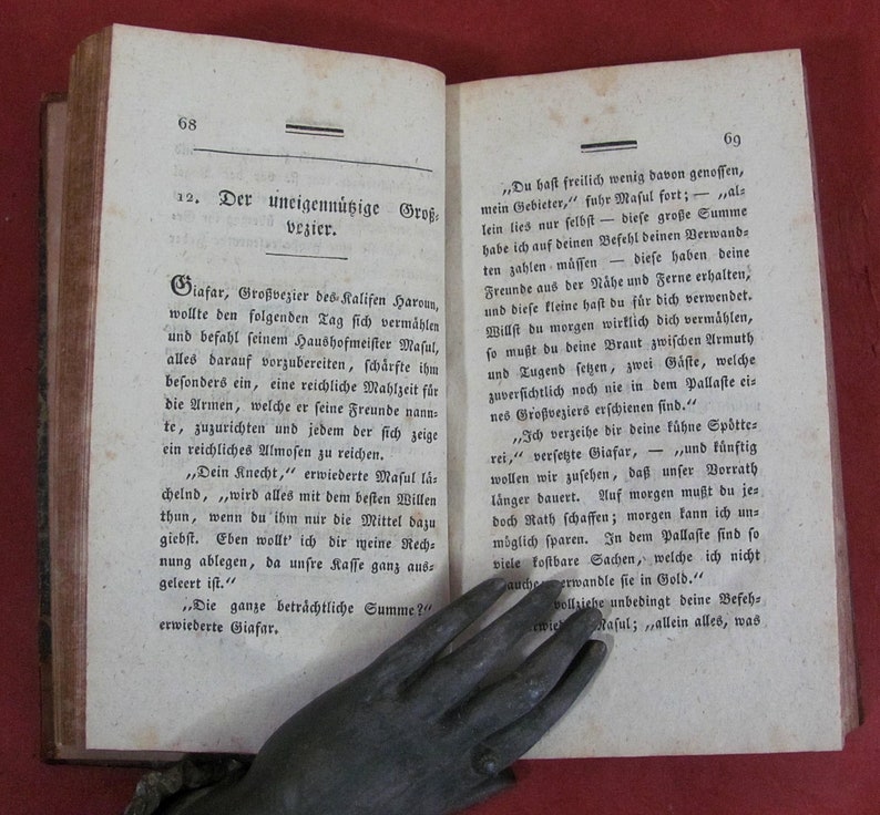 Op de afbeelding: Een open antiek boek met vergeelde pagina's en zwarte gedrukte Duitse tekst. De linkerpagina is genummerd 68 en getiteld 12. Der uneigenn&uuml;tzige Gro&szlig;vezier. De rechterpagina is genummerd 69. Het papier vertoont duidelijke tekenen van veroudering.