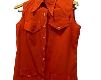 May include: A sleeveless orange button-down shirt with a pointed collar and two large pockets on the front.