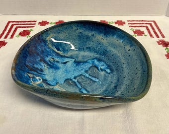 Handmade studio art pottery bowl featuring a unique blue glaze and asymmetrical shape
