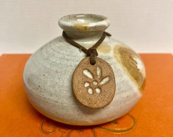 Vintage stoneware ceramic vase weedpot with mottled white and brown glazes and a decorative leather cord