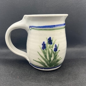 May include: A set of three ceramic mugs with a speckled, matte finish in cream, light grey, and dark grey. Each mug has a simple, minimalist design and a rounded handle.