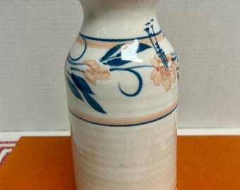 Vintage ceramic vase features hand painted pink and blue floral designs and a flared rim