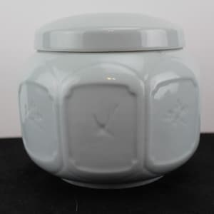 May include: White ceramic jar with a lid. The jar has a geometric design with raised squares and floral motifs.