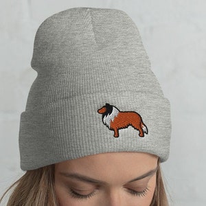 May include: A gray beanie with a brown and white embroidered dog on the front.