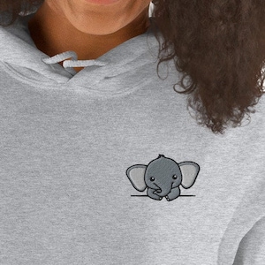 May include: A gray hooded sweatshirt with a small embroidered elephant peeking over the edge of the pocket.