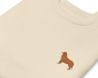 May include: A cream-colored sweatshirt with a brown embroidered dog silhouette.