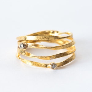 May include: A gold ring with five bands twisted together, set with two small diamonds.