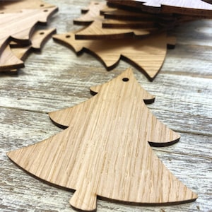 Op de afbeelding: Een set onafgewerkte houten kerstboomversieringen. De versieringen zijn gemaakt van natuurlijk hout en hebben een rustieke uitstraling. Ze zijn perfect om je huis voor de feestdagen te versieren.