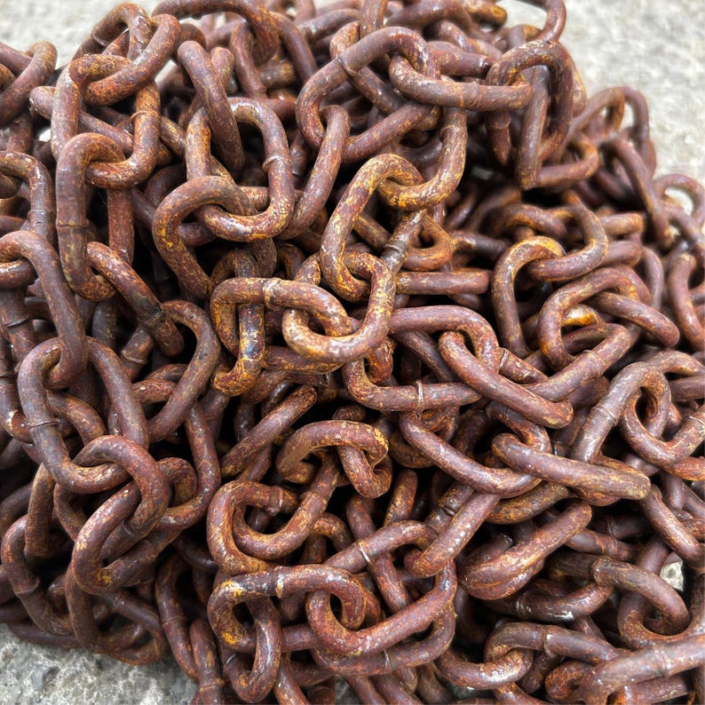 May include: Close-up of a pile of rusty metal chains. The chains are a deep brown color with areas of orange rust. The links are interlocked, creating a dense, textured pattern. The image suggests a vintage or industrial theme.