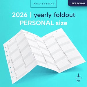 Può includere: Un'agenda personale pieghevole annuale bianca del 2026 su sfondo azzurro. L'agenda è aperta, mostrando il layout del calendario annuale. Sono visibili anche i testi "WHATSHEWAS" e "PERSONAL".