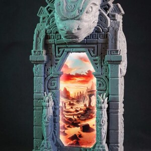 May include: A gray, intricately detailed architectural sculpture featuring a portal with a desert landscape scene. The sculpture has a carved reptilian head at the top and is lit from within, creating a dramatic effect. The overall theme is fantasy and ancient ruins.