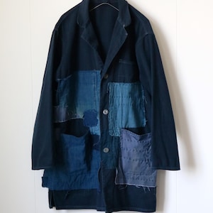 Puede incluir: Chaqueta azul marino con detalles de patchwork en varios tonos de azul. La chaqueta tiene un cuello clásico, cierre de botones y múltiples bolsillos. El patchwork añade una estética única y artesanal a esta prenda.