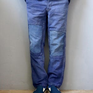 Könnte beinhalten: Blaue Hose mit rechteckigen Knieaufnähern in einem helleren Blauton, die mit sichtbaren dunklen Nähten befestigt sind. Die Hose hat einen geradlinigen Schnitt und wird mit einer passenden blauen Jacke und dunkelblauen Slip-on-Schuhen kombiniert.