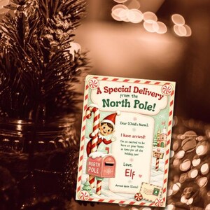 Può includere: Una carta rettangolare intitolata A Special Delivery from the North Pole! con un elfo dei cartoni animati appoggiato a un bastoncino di zucchero e una cassetta postale rosa. La carta include campi per nome, data e una firma.