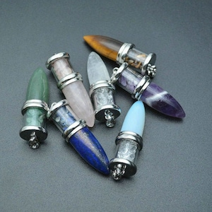 May include: A collection of ten gemstone pendants, each with a silver cap and a pointed tip. The gemstones include amethyst, rose quartz, clear quartz, tiger's eye, green aventurine, and blue lapis lazuli.