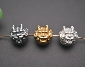 May include: Three round beads with a detailed lion head design. The beads are silver, gold, and silver.