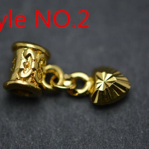 Puede incluir: Encanto dorado con un cilindro decorativo y un colgante en forma de coraz&oacute;n. El encanto est&aacute; unido a una cadena. Estilo NO.2.