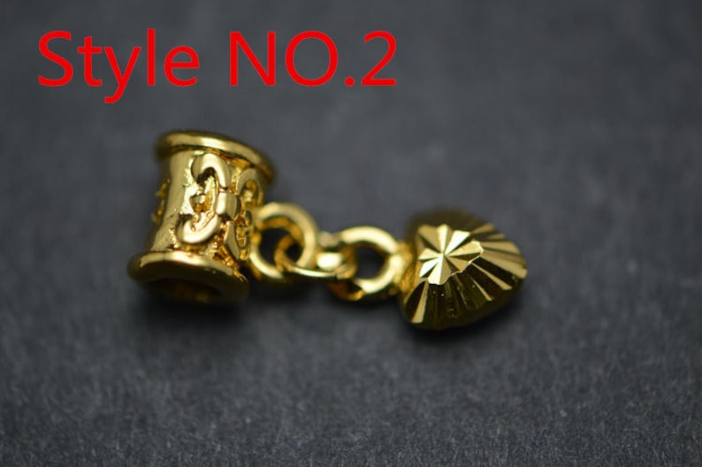 Puede incluir: Encanto dorado con un cilindro decorativo y un colgante en forma de coraz&oacute;n. El encanto est&aacute; unido a una cadena. Estilo NO.2.