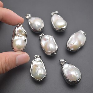 May include: Seven white baroque pearl pendants with silver settings. The pearls are irregular in shape and have a smooth, glossy finish.