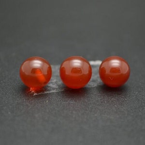 Peut inclure: Trois perles rondes en cornaline rouge. Les perles sont lisses et polies.
