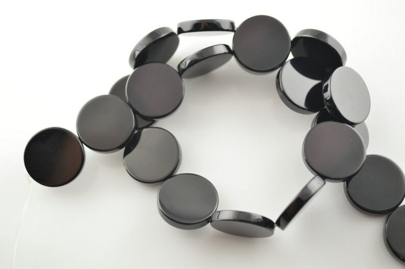 May include: A strand of black onyx beads, each bead is a flat, round disc.