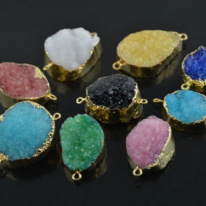 May include: Assortment of ten colourful crystal gemstone pendants with gold-toned metal settings. Each pendant features a unique, irregular shape and a textured surface.