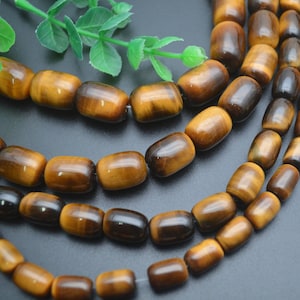 May include: A strand of brown and gold tiger's eye beads. The beads are oval shaped and have a smooth, polished finish.