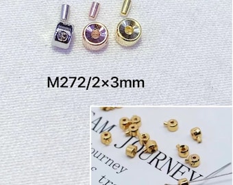 May include: A collection of jewelry findings, including gold, silver, and rose gold-colored crimp beads, clasps, and end caps. The text "M272/2x3mm" is visible. These components are used in jewelry making.