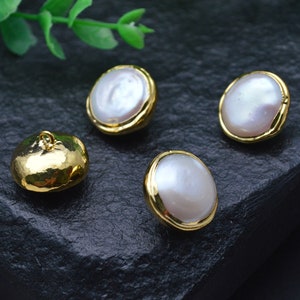 May include: Four round buttons with a gold metal rim and a white pearl center. One button has a gold loop on the top.