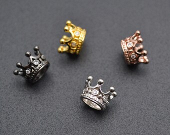 May include: Four crown-shaped metal beads with clear rhinestones. The beads are in gold, silver, black, and rose gold.