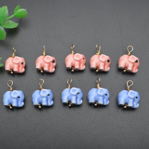 May include: A set of 10 ceramic elephant charms, 5 in pink and 5 in blue. Each charm has a gold loop for attaching to jewelry or other crafts.