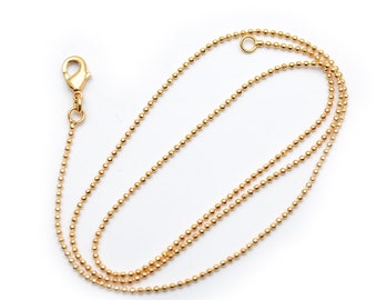 May include: A gold chain necklace with a lobster clasp closure. The chain is made of small, round beads.