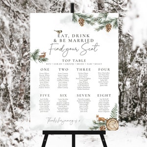 May include: A winter-themed wedding seating chart with a watercolour background. The chart features a rustic design with pine branches, pine cones, and a deer. The text reads "Eat, Drink & Be Married. Find Your Seat." and lists the names of guests at each table.