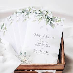 May include: Order of service for a wedding ceremony with a watercolour design of green leaves and gold accents. The text reads "Order of Service" for the marriage of Gary Davies & Lisa Chatham, 02.10.2024, St James' Church, Cardington.