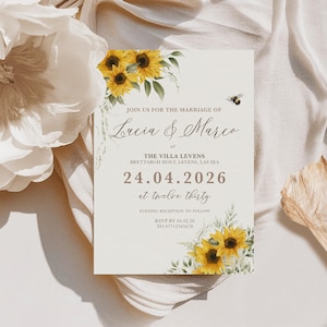 May include: A cream-coloured wedding invitation card with a sunflower and foliage design. The text reads "Join us for the marriage of Lucia & Marco" and the date is 24.04.2026. A small illustration of a bee is also present.