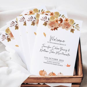May include: Welcome to the marriage service of Jennifer Chloe Young & Nathan John Murthwaite on 7th October 2022 at St John the Baptist, Werrington Parish Church. The invitation features a watercolour illustration of autumn leaves and pumpkins.