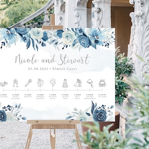May include: A wedding welcome sign with a blue watercolor floral design. The sign includes the names "Nicole and Stewart" and the date "03.08.2023". The sign also includes a timeline of wedding events with icons.