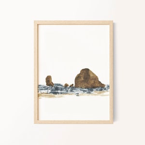 May include: A framed watercolor painting of a rocky island with a brown and gray color scheme. The island is surrounded by a blue and white watercolor depiction of water.