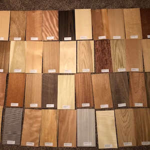 May include: A collection of 40 wood veneer samples, showcasing a variety of colours, grains, and patterns. The samples are arranged in four rows of ten, with each sample labelled with its name.