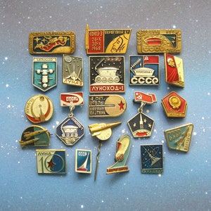 May include: A collection of 20 vintage Soviet space program enamel pins. The pins feature various spacecraft, astronauts, and slogans in Russian and English. The pins are in excellent condition and would be a great addition to any space enthusiast's collection.