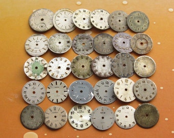 May include: A collection of 25 vintage watch faces in various styles and colours. The faces are round and have different numbers, markings, and designs. Some of the faces are silver, some are gold, and some are black.