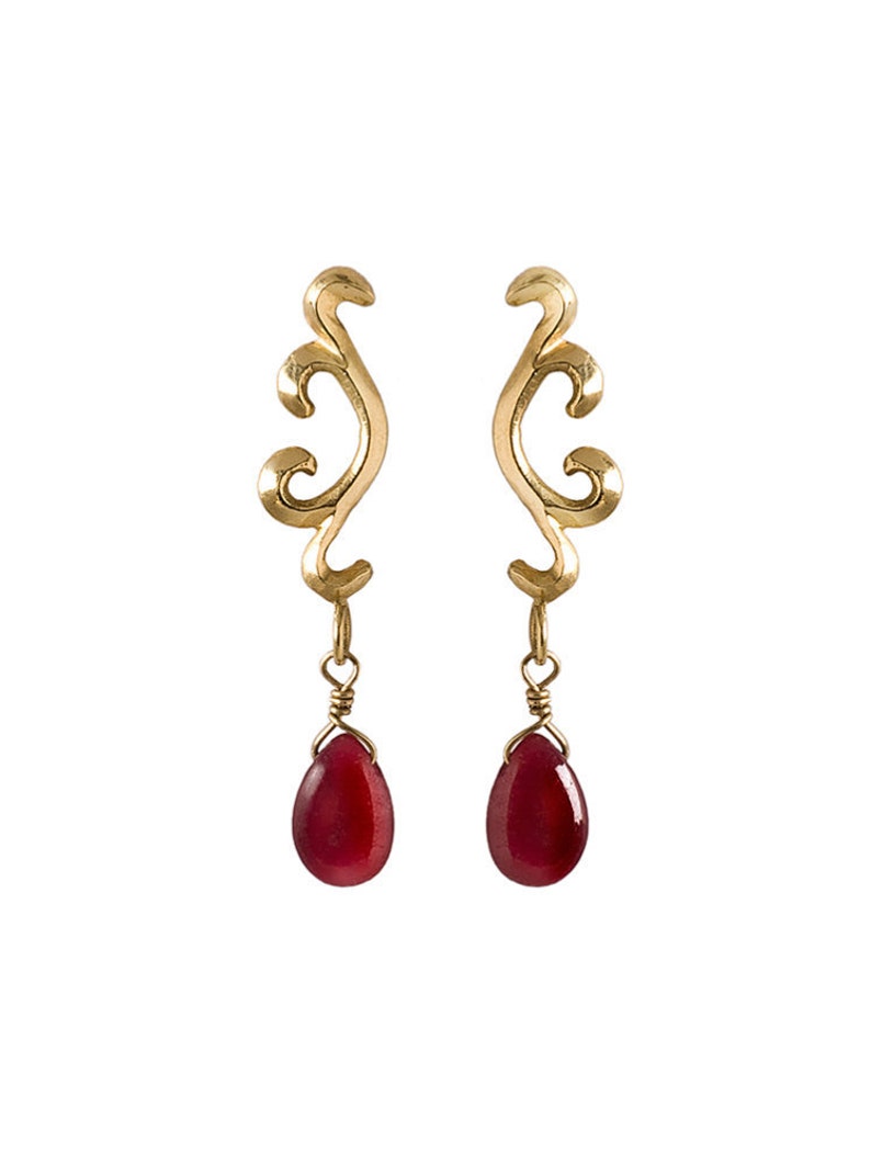 May include: Gold earrings with a delicate, swirling design and dangling red teardrop-shaped stones.