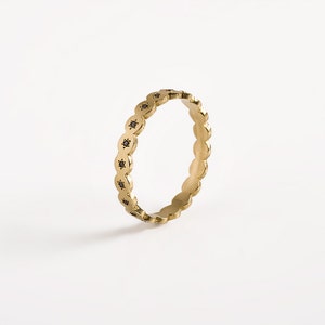 May include: A gold band ring with a scalloped edge and black diamonds set in each scallop.