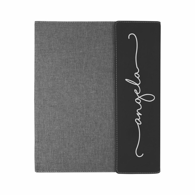 May include: A gray and black fabric binder with the word "angela" written in white cursive on the black side.