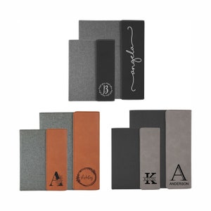 May include: Three sets of personalized leatherette and fabric journals. The first set is gray and black with the name "angela" in cursive. The second set is gray and brown with the initial "A" and the name "Achilles" in a wreath. The third set is gray and black with the initial "K" and the name "KEVIN" and the initial "A" with the name "ANDERSON".